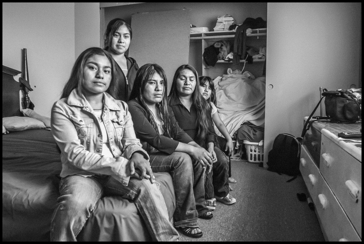The Diaz family, Mixtec immigrants from Oaxaca, sleep and live in a single room in a house in Oxnard, where other migrant families also live. The Diaz family are strawberry workers. From the left, Guillermina Ortiz Diaz, Graciela, Eliadora, their mother Bernardina Diaz Martinez, and little sister Ana Lilia. (Photo © David Bacon)