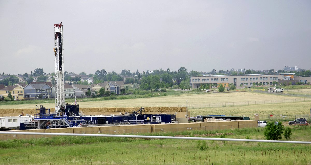 Drill rig working to drill a natural gas well to be fracked next to the Red Hawk Elementary School. Elementary school is the building behind the drill rig in the photo.