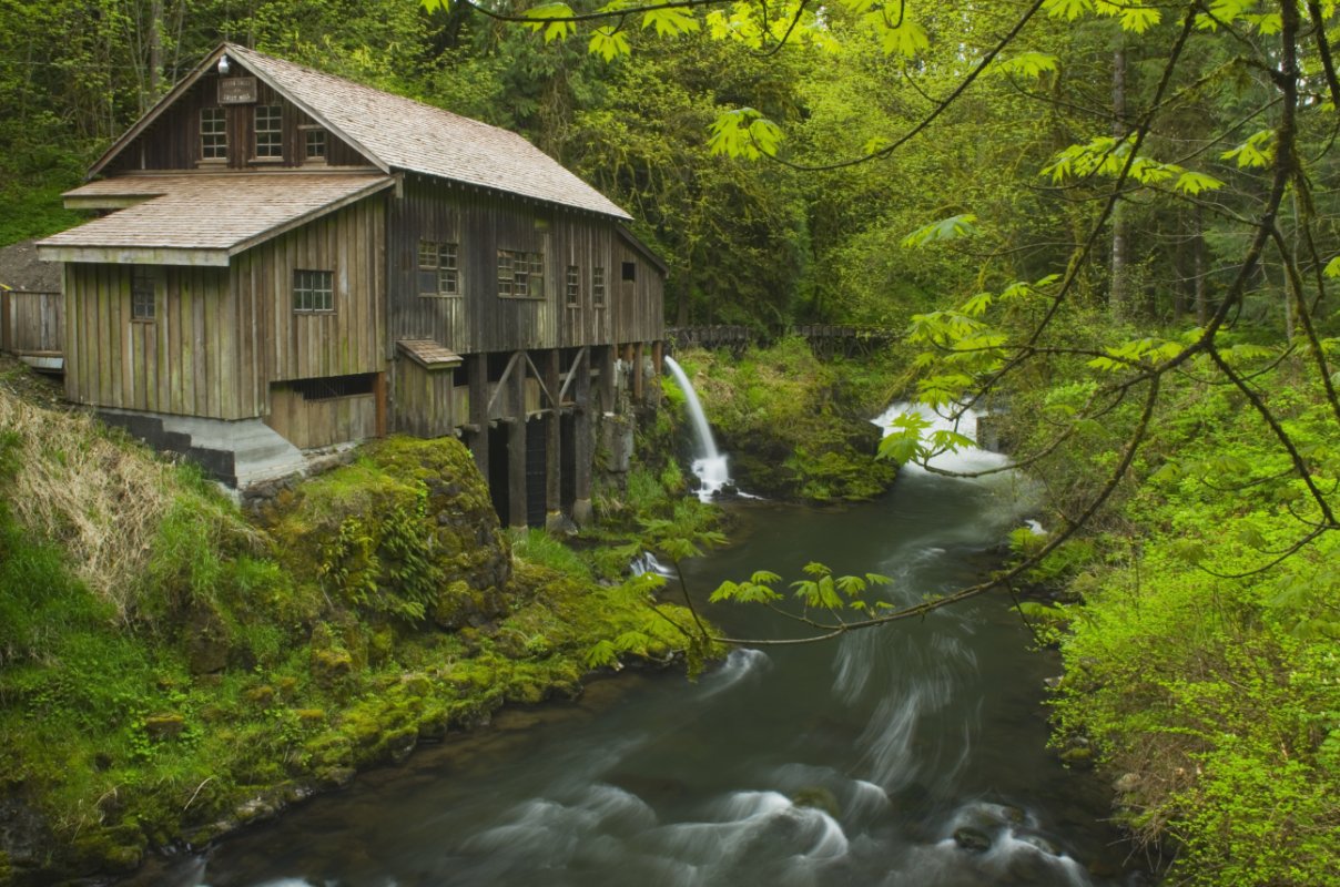 a scenic old grist mill powered by a stream in the woods
