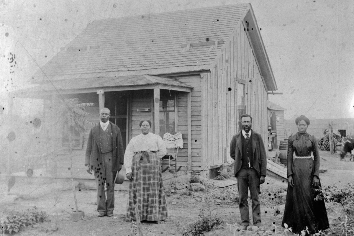 a black and white photo of a Black family on a homestead in Kansas