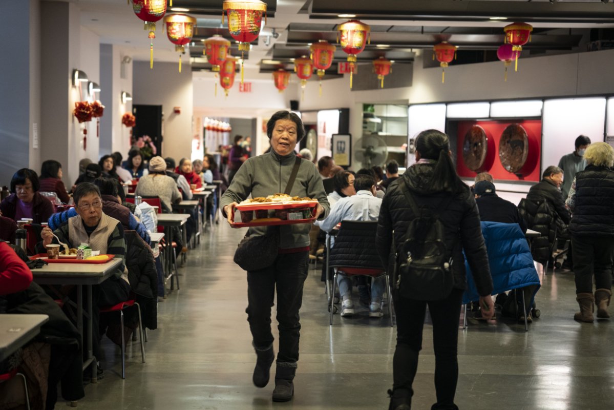 An elder heads toward a table of friends at Manhattan’s Open Door Senior Center.