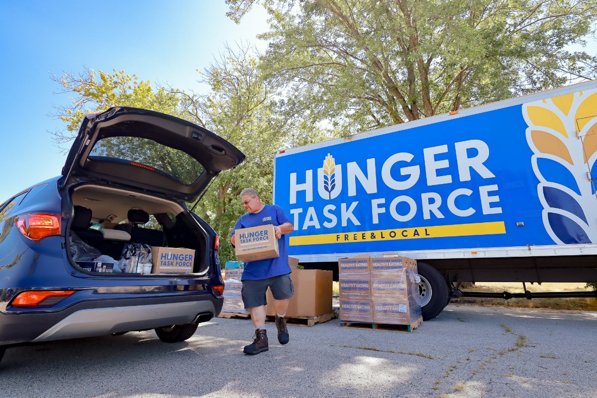 A member of the Hunger Task Force team loading a senior Stockbox into the vehicle of a recipient at a distribution in Milwaukee County.