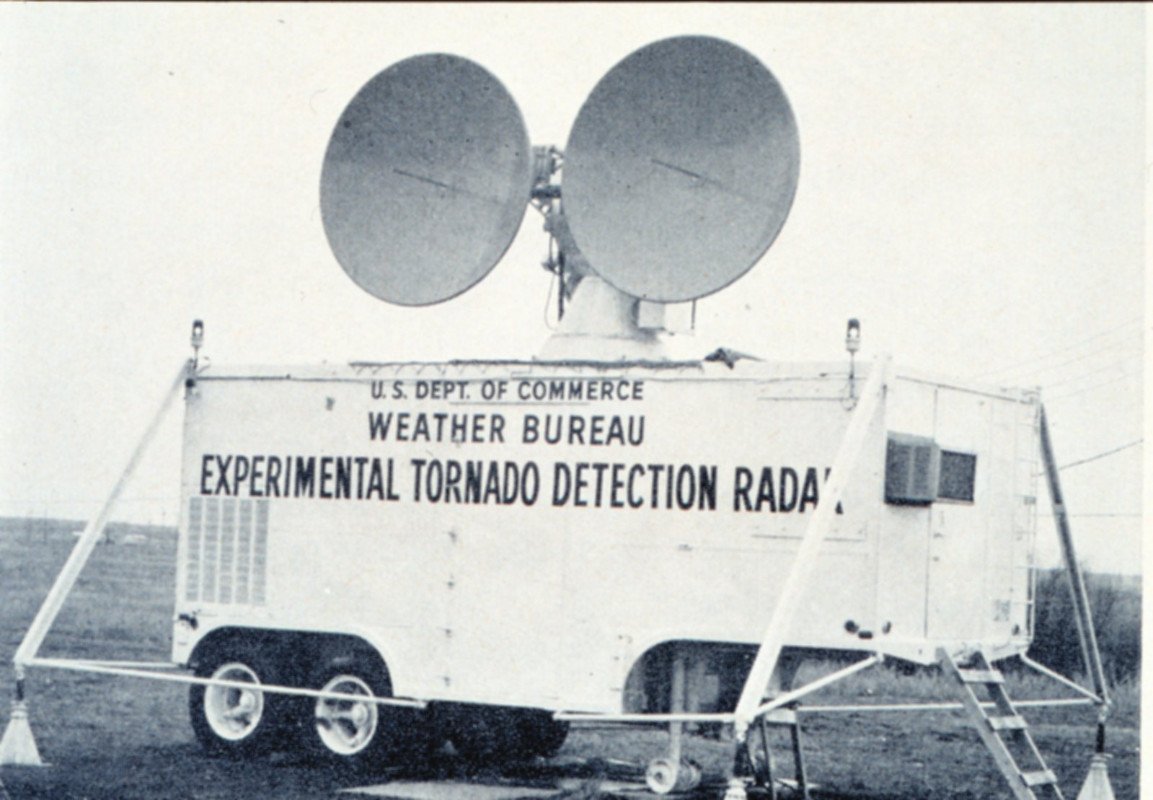 a black and white photo of a large van with two circular panels on top for tornado tracking