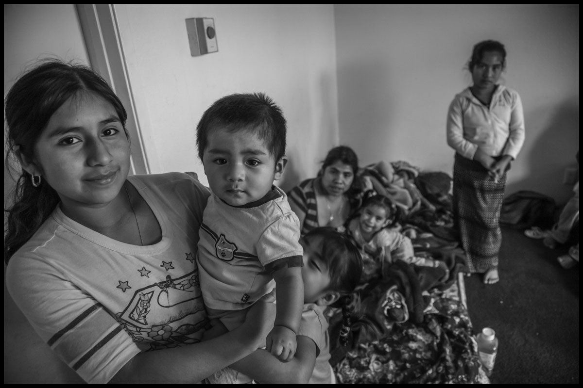 Sabina Cayetano, a strawberry picker, and her son Aron and other members of her family sleep in one room in their Santa Maria apartment. (Photo credit: David Bacon)